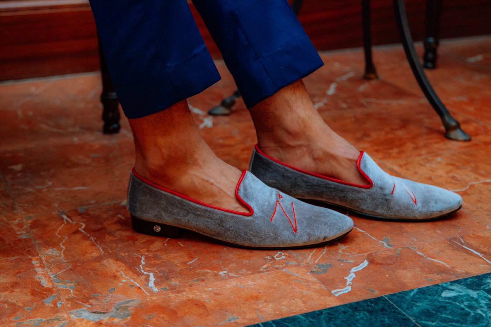 A closeup of the grey color velvet loafer with logo