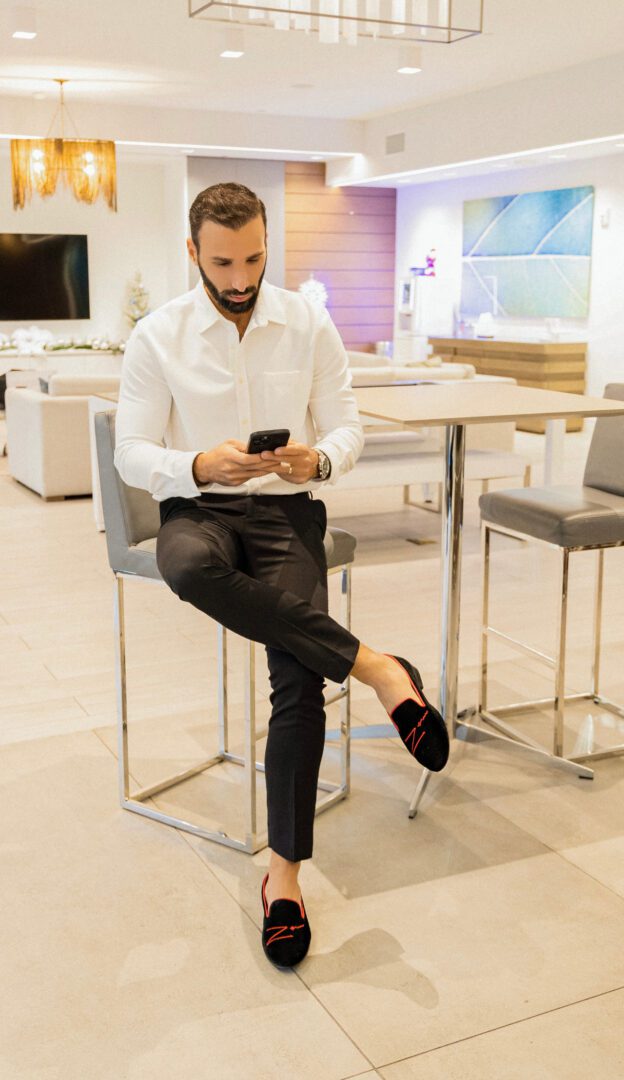 A man in a black color loafer and white color shirt