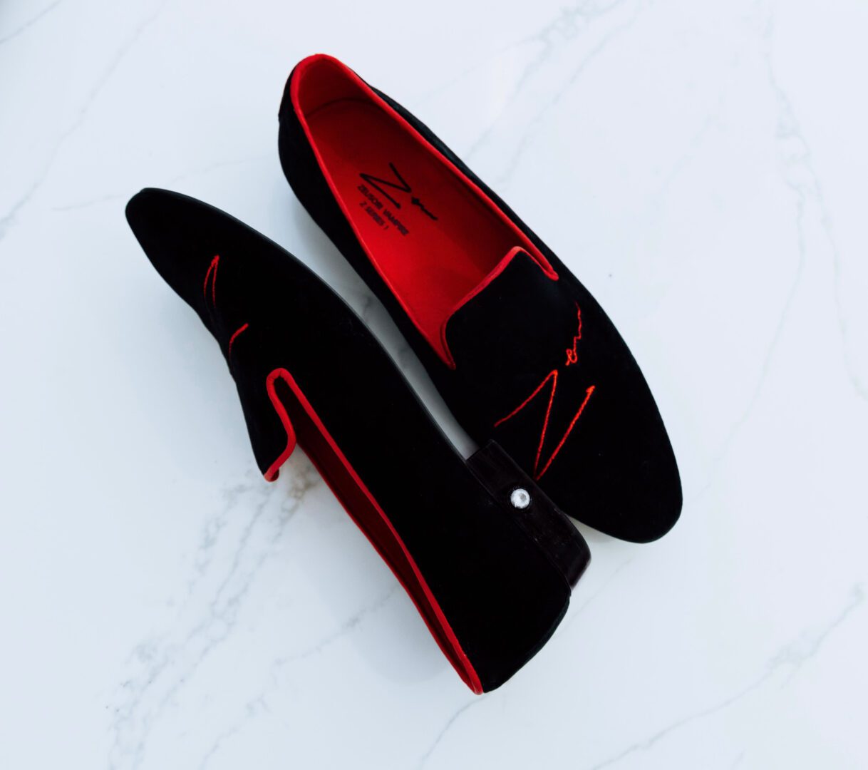 A picture of the black and red loafers with zeusori logo